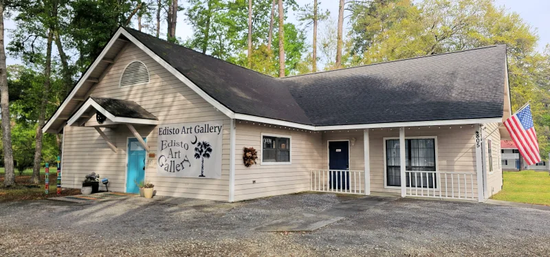 The front of the Edisto Art Gallery building, with its sign and teal door